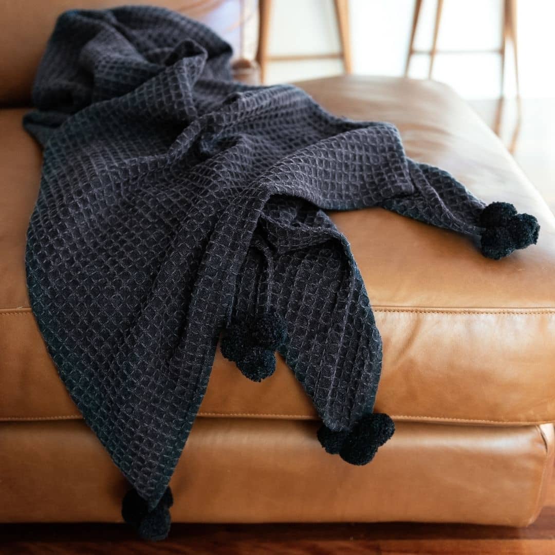 black cotton waffle throw with stone-washed finish and pom poms - 170x130cm